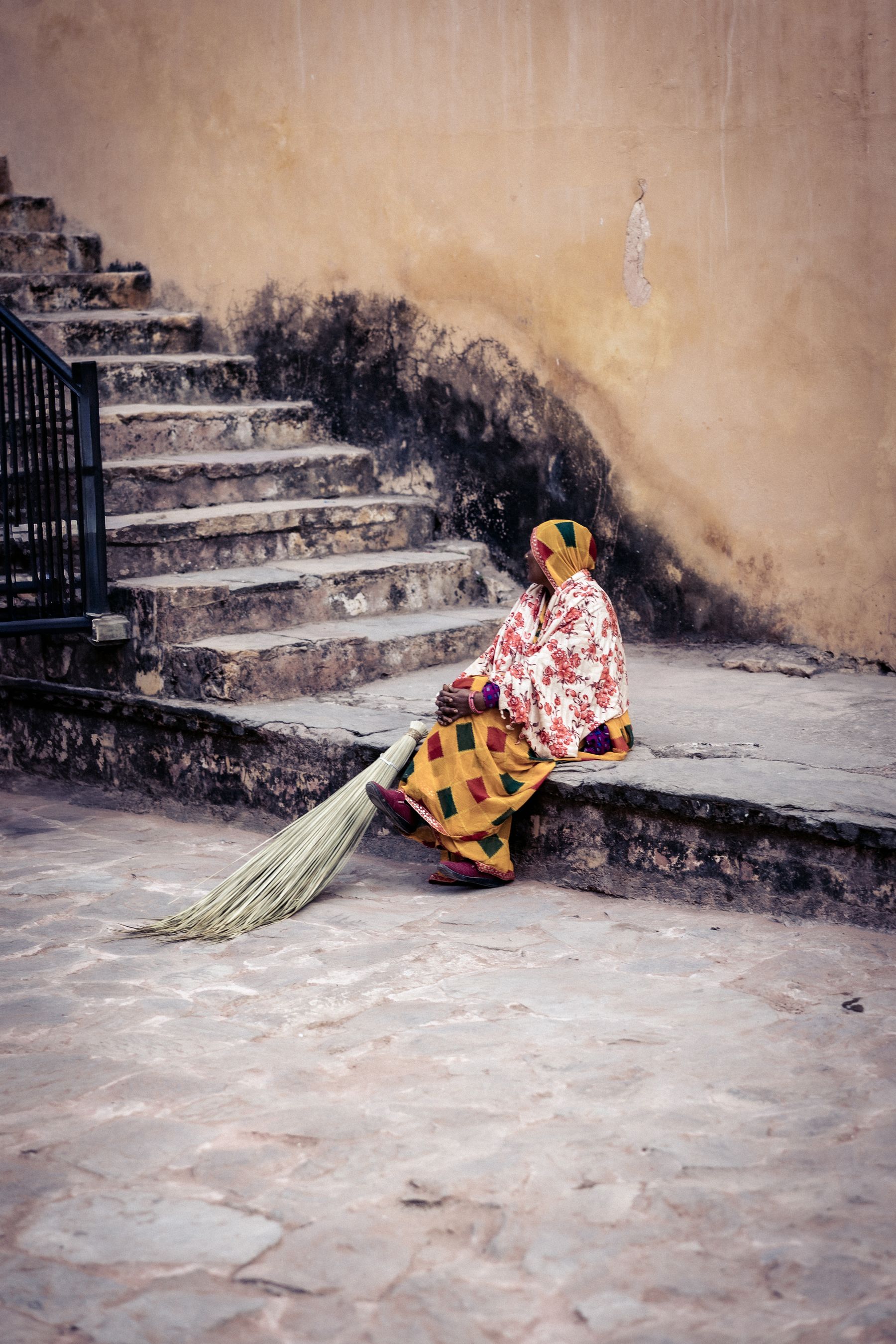 Woman Caretaker Seated With Broom On Steps